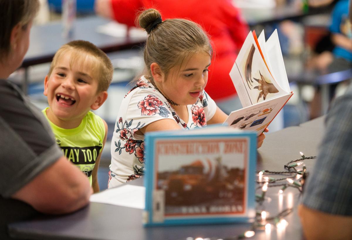 Student enjoying her book at Cabell Flashlight Night distribution