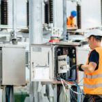 Adult electrical engineer mount the electrical systems at the equipment control cabinet. Installation of modern electrical station