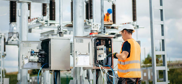 Adult electrical engineer mount the electrical systems at the equipment control cabinet. Installation of modern electrical station