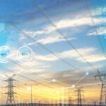 High-voltage power lines and lattice towers against a blue sky with faint digital data graphics overlayed.